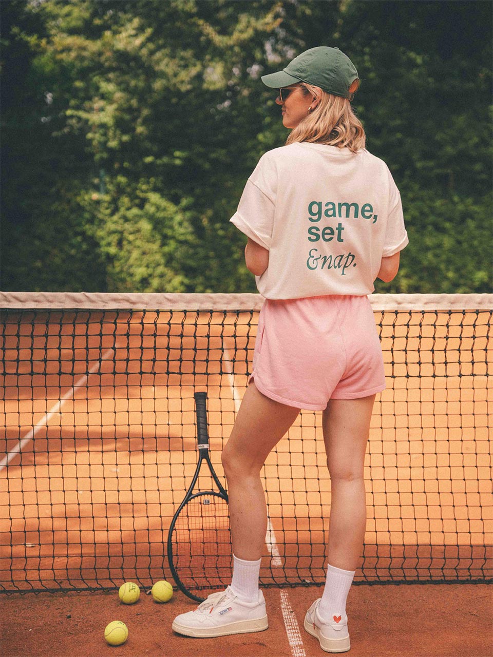 Modell trägt „game, set & nap.“ T-Shirt von Almost a Brand auf dem Tennisplatz